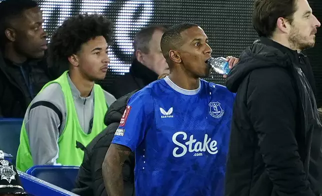 Peterborough United's Tyler Young, left, sits on the substitute's bench as his father Everton's Ashley Young, center, prepares to enter the game during the English FA Cup third round soccer match between Everton and Peterborough United at Goodison Park, Liverpool, England, Thursday Jan. 9, 2025. (Peter Byrne/PA via AP)