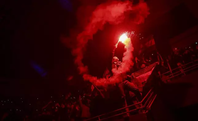 A fan holds a flare during a concert by the recently returned "revolutionary" singer Wasfi Maasrani in Damascus late Wednesday Jan. 8, 2025..(AP Photo/Ghaith Alsayed)
