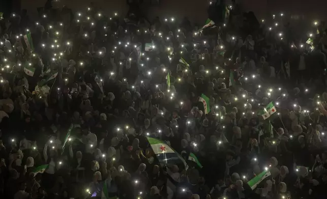Syrians sing and wave post-Assad flags during a concert by the recently returned "revolutionary" singer Wasfi Maasrani in Damascus Wednesday Jan. 8, 2025..(AP Photo/Ghaith Alsayed)