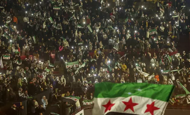 Syrians sing and wave post-Assad flags during a concert by the recently returned "revolutionary" singer Wasfi Maasrani in Damascus Wednesday Jan. 8, 2025..(AP Photo/Ghaith Alsayed)
