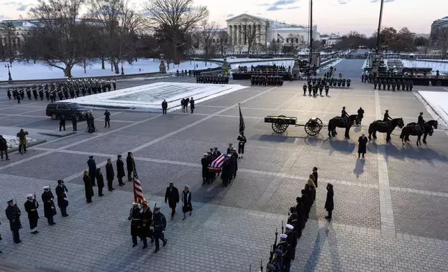 A joint services body bearer team moves the casket of former President Jimmy Carter after it arrived on a horse-drawn caisson at the East Front of U.S. Capitol in Washington, Tuesday, Jan. 7, 2025. (Shawn Thew/Pool via AP)