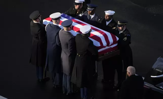 The flag-draped casket of former President Jimmy Carter is transferred to a horse-drawn caisson at the U.S. Navy Memorial before traveling on to the Capitol in Washington, Tuesday, Jan. 7, 2025, where Carter will lie in state. Carter died Dec. 29 at the age of 100. (AP Photo/Mark Schiefelbein, Pool)