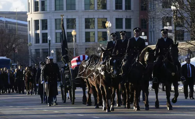 The casket containing the remains of former President Jimmy Carter moves on Constitution Avenue toward the U.S. Capitol on a horse-drawn caisson in Washington, Tuesday, Jan. 7, 2025. Carter died Dec. 29, 2024, at the age of 100. (AP Photo/Susan Walsh, Pool)