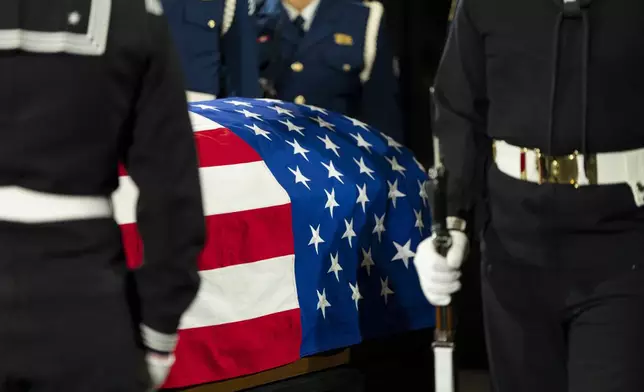 Mourners view the changing of guard of the joint services military honor guard as the casket of former President Jimmy Carter as he lies in repose at the Jimmy Carter Presidential Library and Museum in Atlanta, Tuesday, Jan. 7, 2025. Carter died Dec. 29 at the age of 100. (AP Photo/Alex Brandon, Pool)