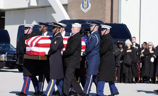 A joint forces military body bearer team moves flag-draped casket of former President Jimmy Carter to Special Air Mission 39 at Dobbins Air Reserve Base in Marietta, Ga., Tuesday, Jan. 7, 2025. Carter died Dec. 29 at the age of 100. (AP Photo/Alex Brandon, Pool)