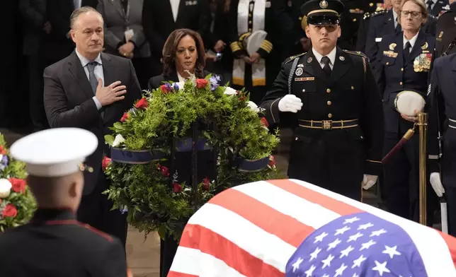 Second gentleman Doug Emhoff, from left, and Vice President Kamala Harris place a wreath at the flag-draped casket of former President Jimmy Carter during a ceremony where Carter lies in state at the Capitol in Washington, Tuesday, Jan. 7, 2025. Carter died Dec. 29 at the age of 100. (AP Photo/J. Scott Applewhite, Pool)