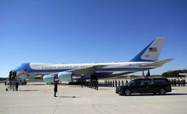 The hearse carrying flag-draped casket of former President Jimmy Carter arrives at Dobbins Air Reserve Base in Marietta, Ga., Tuesday, Jan. 7, 2025. Carter died Dec. 29 at the age of 100. (AP Photo/Alex Brandon, Pool)