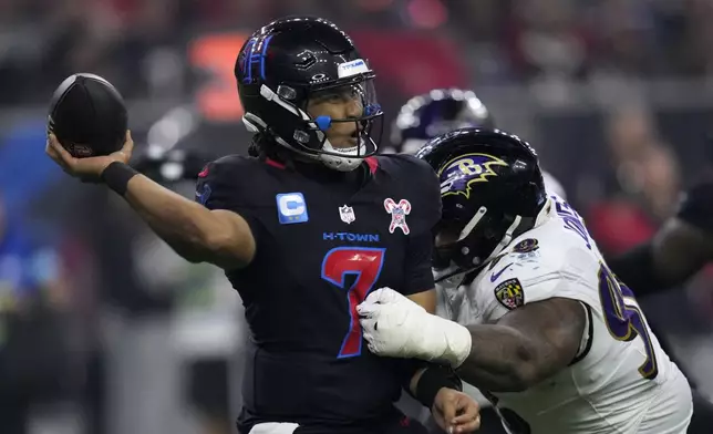 Houston Texans quarterback C.J. Stroud (7) passes as he is pressured by Baltimore Ravens defensive tackle Travis Jones (98) during the second half of an NFL football game, Wednesday, Dec. 25, 2024, in Houston. (AP Photo/David J. Phillip)