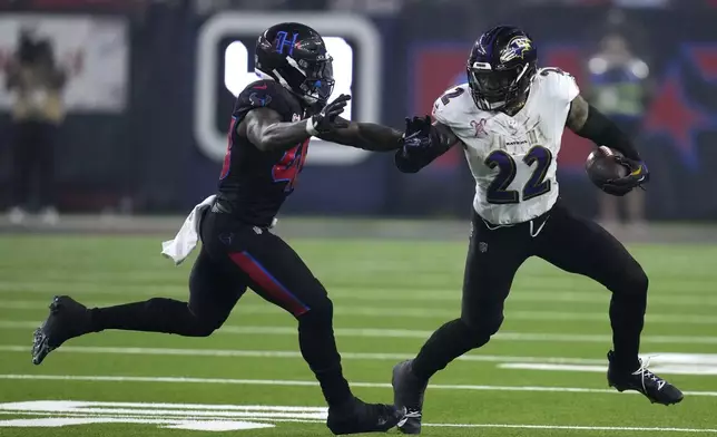 Baltimore Ravens running back Derrick Henry (22) tries to break a tackle by Houston Texans linebacker Christian Harris, left, during the second half of an NFL football game, Wednesday, Dec. 25, 2024, in Houston. (AP Photo/David J. Phillip)