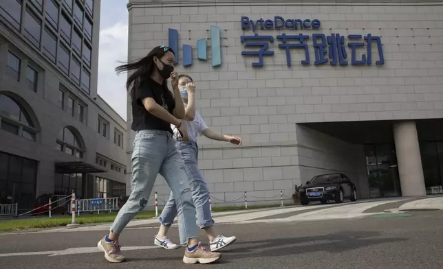 FILE - Women wearing masks to pass by the headquarters of ByteDance, owners of TikTok, in Beijing, China, Aug. 7, 2020. (AP Photo/Ng Han Guan, File)