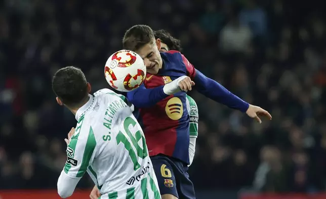 Barcelona's Gavi, right, jumps for the ball with Betis' Sergi Altimira during a Spanish Copa del Rey round of 16 soccer match between Barcelona and Real Betis at the Lluis Companys Olympic Stadium in Barcelona, Spain, Wednesday, Jan. 15, 2025. (AP Photo/Joan Monfort)