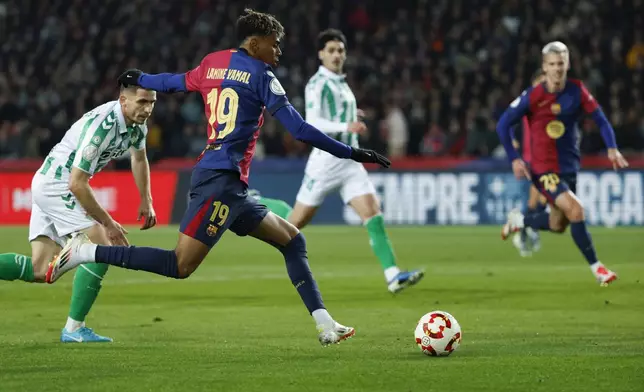 Barcelona's Lamine Yamal, front, controls the ball during a Spanish Copa del Rey round of 16 soccer match between Barcelona and Real Betis at the Lluis Companys Olympic Stadium in Barcelona, Spain, Wednesday, Jan. 15, 2025. (AP Photo/Joan Monfort)