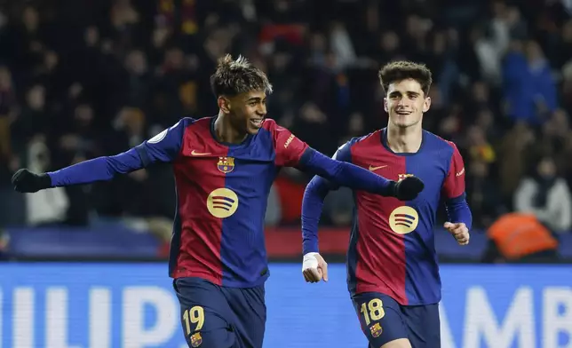 Barcelona's Lamine Yamal, left, celebrates with Barcelona's Pau Victor after scoring his side's fifth goal during a Spanish Copa del Rey round of 16 soccer match between Barcelona and Real Betis at the Lluis Companys Olympic Stadium in Barcelona, Spain, Wednesday, Jan. 15, 2025. (AP Photo/Joan Monfort)