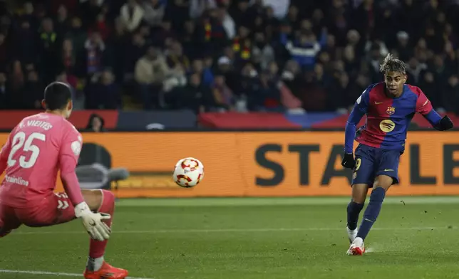 Barcelona's Lamine Yamal, right, scores his side's fifth goal during a Spanish Copa del Rey round of 16 soccer match between Barcelona and Real Betis at the Lluis Companys Olympic Stadium in Barcelona, Spain, Wednesday, Jan. 15, 2025. (AP Photo/Joan Monfort)