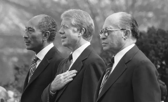 FILE - Egyptian President Anwar Sadat, left, U.S. President Jimmy Carter, center, and Israeli Prime Minister Menachem Begin, stand at attention as the national anthems of their respective countries are played on the north lawn of the White House in Washington, on Feb. 24, 1979. (AP Photo, File)