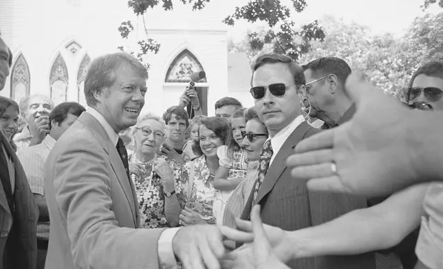 FILE - Democratic nominee Jimmy Carter shakes hands with church-goers outside the Plains Baptist Church, in Plains, Ga., on July 18, 1976. (AP Photo/Peter Bregg, File)