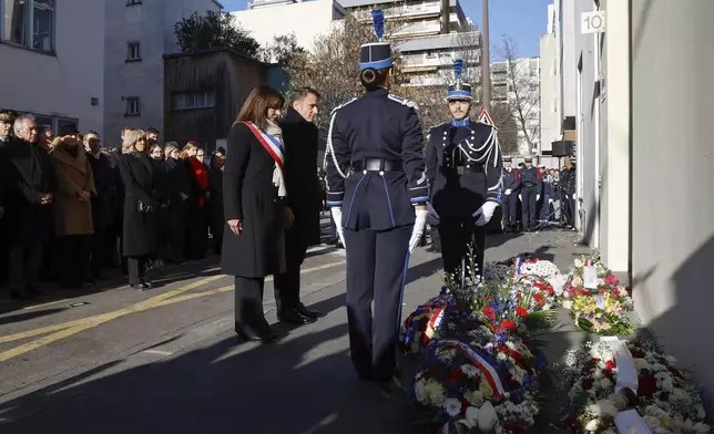 French President Emmanuel Macron, and Paris Mayor Anne Hidalgo, center left, attend a commemoration marking 10 years since an Islamist attack on the Charlie Hebdo satirical newspaper and the Hypercacher jewish supermarket, outside the weekly's former offices in Paris Tuesday Jan. 7, 2025. (Ludovic Marin, Pool via AP)