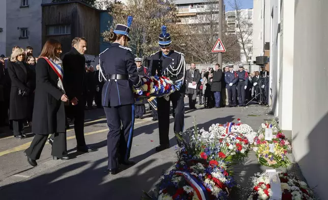 French President Emmanuel Macron, and Paris Mayor Anne Hidalgo, left, attend a commemoration marking 10 years since an Islamist attack on the Charlie Hebdo satirical newspaper and the Hypercacher jewish supermarket, outside the weekly's former offices in Paris Tuesday Jan. 7, 2025. (Ludovic Marin, Pool via AP)