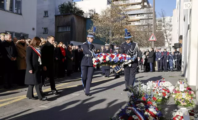 French President Emmanuel Macron, and Paris Mayor Anne Hidalgo, left, arrive to lay a wreath during a commemoration marking 10 years since an Islamist attack on the Charlie Hebdo satirical newspaper and the Hypercacher jewish supermarket, outside the weekly's former offices in Paris Tuesday Jan. 7, 2025. (Ludovic Marin, Pool via AP)