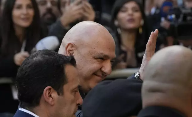 Newly-elected Lebanese President Joseph Aoun, center, smiles and waves to journalists upon his arrival at the Lebanese Parliament to be sworn in as a new president, in Beirut, Lebanon, Thursday, Jan. 9, 2025. (AP Photo/Hussein Malla)