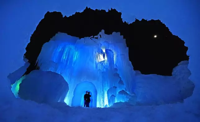 A couple shares a romantic moment in a cave at Ice Castles, Friday, Jan. 10, 2025, in North Woodstock, N.H. (AP Photo/Robert F. Bukaty)