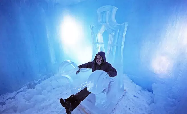 Julia Jones, of Gloucester, Mass., sits on an ice throne at Ice Castles, Friday, Jan. 10, 2025, in North Woodstock, N.H. (AP Photo/Robert F. Bukaty)