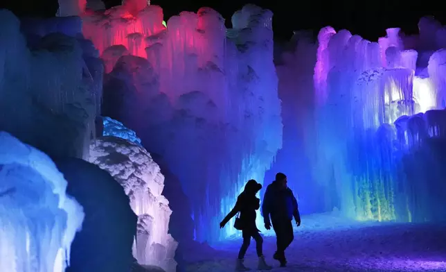 Colorful lights shine inside inside the walls of ice at Ice Castles, Friday, Jan. 10, 2025, in North Woodstock, N.H. (AP Photo/Robert F. Bukaty)