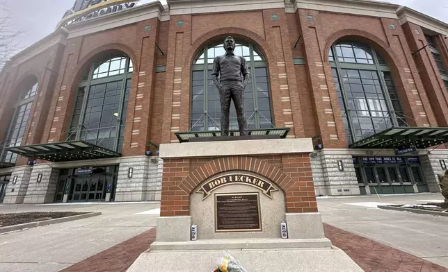 Flowers lay near a statue of Bob Uecker outside American Family Field in Milwaukee on Thursday, Jan. 16, 2025. (AP Photo/Steve Megargee)