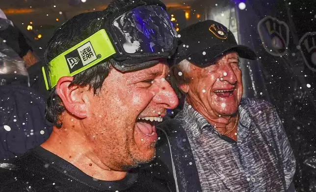 FILE - Milwaukee Brewers' owner Mark Attanasio and broadcaster Bob Uecker celebrate after clinching the National League Central Division after a baseball game against the St. Louis Cardinals Tuesday, Sept. 26, 2023, in Milwaukee. (AP Photo/Morry Gash)