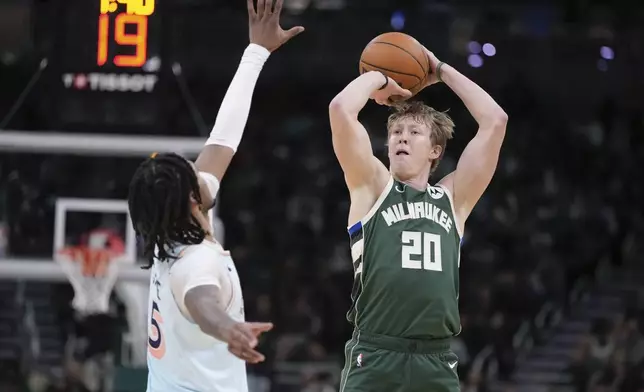 Milwaukee Bucks' AJ Green shoots a three in front of San Antonio Spurs' Stephon Castle during the first half of an NBA basketball game Wednesday, Jan. 8, 2025, in Milwaukee. (AP Photo/Morry Gash)