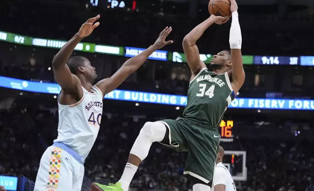 Milwaukee Bucks' Giannis Antetokounmpo shoots past San Antonio Spurs' Harrison Barnes during the first half of an NBA basketball game Wednesday, Jan. 8, 2025, in Milwaukee. (AP Photo/Morry Gash)