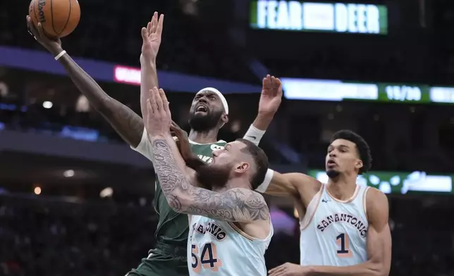 Milwaukee Bucks' Bobby Portis shoots past San Antonio Spurs' Victor Wembanyama and Sandro Mamukelashvili during the first half of an NBA basketball game Wednesday, Jan. 8, 2025, in Milwaukee. (AP Photo/Morry Gash)