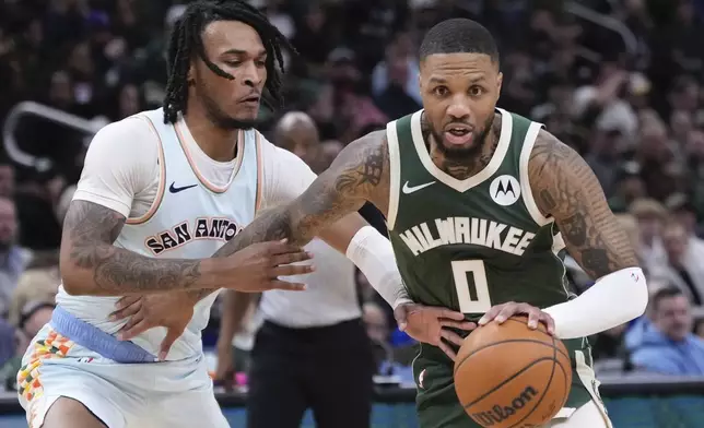 Milwaukee Bucks' Damian Lillard gets past San Antonio Spurs' Stephon Castle during the first half of an NBA basketball game Wednesday, Jan. 8, 2025, in Milwaukee. (AP Photo/Morry Gash)