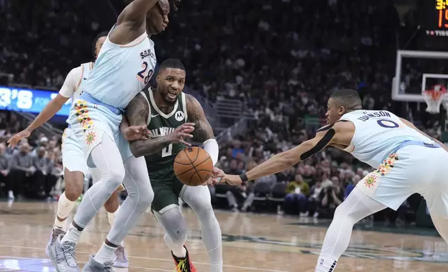 San Antonio Spurs' Keldon Johnson knocks the ball from Milwaukee Bucks' Damian Lillard during the first half of an NBA basketball game Wednesday, Jan. 8, 2025, in Milwaukee. (AP Photo/Morry Gash)