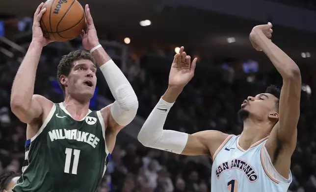 Milwaukee Bucks' Brook Lopez shoots past San Antonio Spurs' Victor Wembanyama during the first half of an NBA basketball game Wednesday, Jan. 8, 2025, in Milwaukee. (AP Photo/Morry Gash)