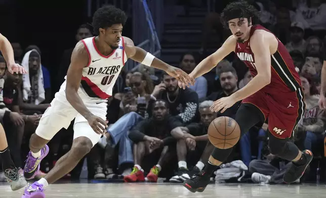 Portland Trail Blazers guard Scoot Henderson (00) and Miami Heat guard Jaime Jaquez Jr., right, go for a loose ball during the second half of an NBA basketball game, Tuesday, Jan. 21, 2025, in Miami. (AP Photo/Lynne Sladky)