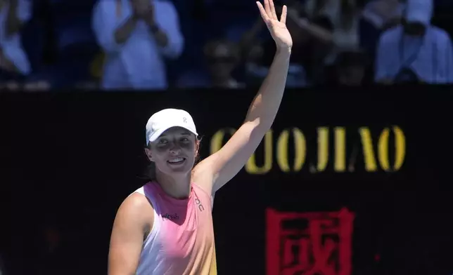 Iga Swiatek of Poland waves after defeating Emma Raducanu of Britain in their third round match at the Australian Open tennis championship in Melbourne, Australia, Saturday, Jan. 18, 2025. (AP Photo/Asanka Brendon Ratnayake)