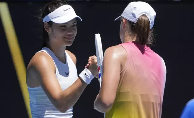 Emma Raducanu of Britain congratulates Iga Swiatek, right, of Poland following their third round match at the Australian Open tennis championship in Melbourne, Australia, Saturday, Jan. 18, 2025. (AP Photo/Asanka Brendon Ratnayake)