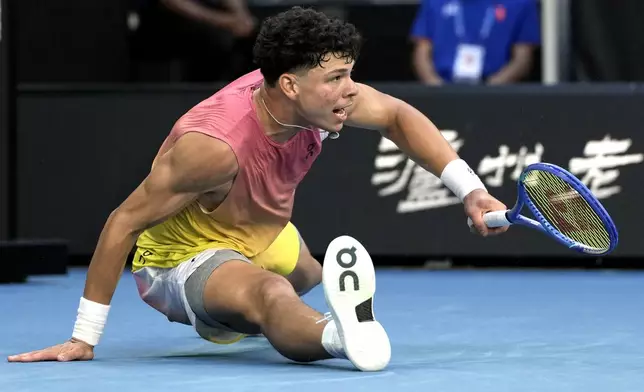 Ben Shelton of the U.S. falls during his third round match against Lorenzo Musetti of Italy at the Australian Open tennis championship in Melbourne, Australia, Saturday, Jan. 18, 2025. (AP Photo/Ng Han Guan)