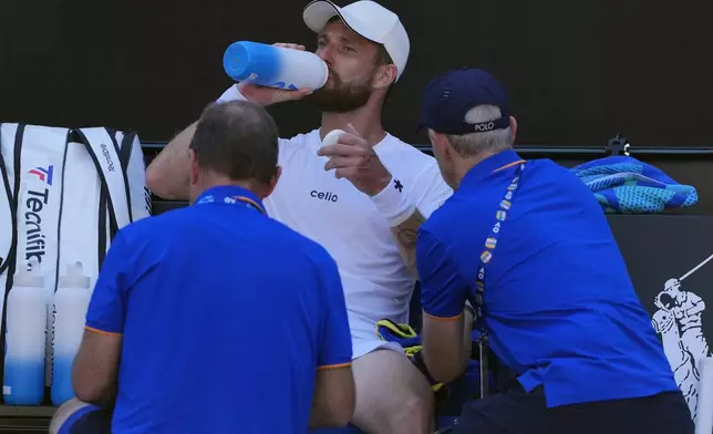 Corentin Moutet of France receives treatment from a trainer during his third round match against Learner Tien of the U.S. at the Australian Open tennis championship in Melbourne, Australia, Saturday, Jan. 18, 2025. (AP Photo/Vincent Thian)