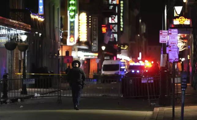 An officer walks along Conti Street after a vehicle drove into a crowd on New Orleans' Canal and Bourbon streets, Wednesday, Jan. 1, 2025. (AP Photo/George Walker IV)