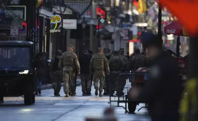 Military personnel walk down Bourbon street, Thursday, Jan. 2, 2025 in New Orleans. (AP Photo/George Walker IV)