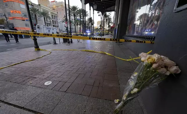 A bouquet of flowers stands at the intersection of Bourbon Street and Canal Street during the investigation after a pickup truck rammed into a crowd of revelers early on New Year's Day, Wednesday, Jan. 1, 2025, in New Orleans. (AP Photo/Matthew Hinton)