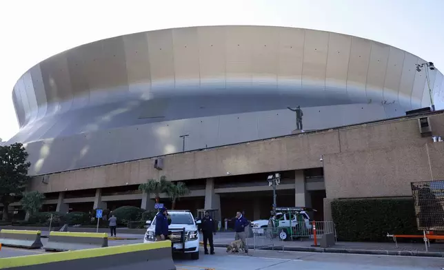 Security and bomb sniffing dogs check vehicles as they enter the Superdome parking garage ahead of the Sugar Bowl NCAA College Football Playoff game, Thursday, Jan. 2, 2025, in New Orleans. (AP Photo/Butch Dill)