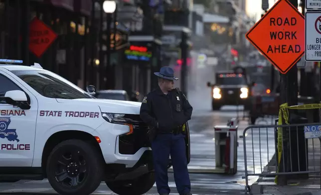 A state trooper stands by New Orleans' Canal and Bourbon streets, Thursday, Jan. 2, 2025. (AP Photo/George Walker IV)