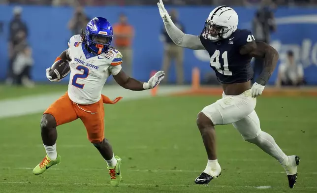 Boise State running back Ashton Jeanty (2) runs as Penn State linebacker Kobe King (41) pursues during the first half of the Fiesta Bowl NCAA college football CFP quarterfinal game, Tuesday, Dec. 31, 2024, in Glendale, Ariz. (AP Photo/Ross D. Franklin)