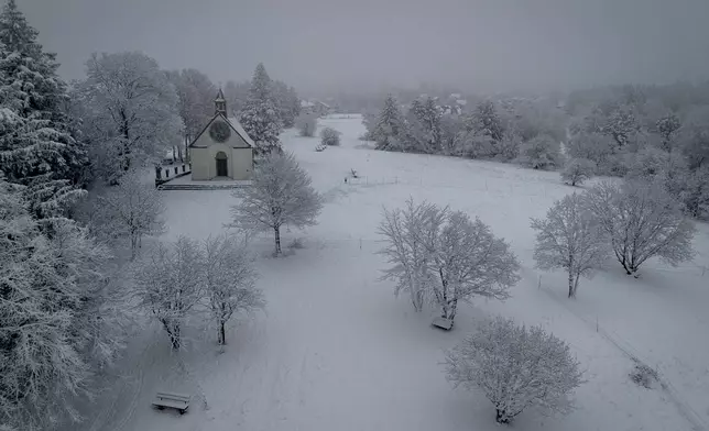 Snow blankets the meadow near a chapel in the Taunus region near Frankfurt, Germany, Friday, Jan. 3, 2025. (AP Photo/Michael Probst)