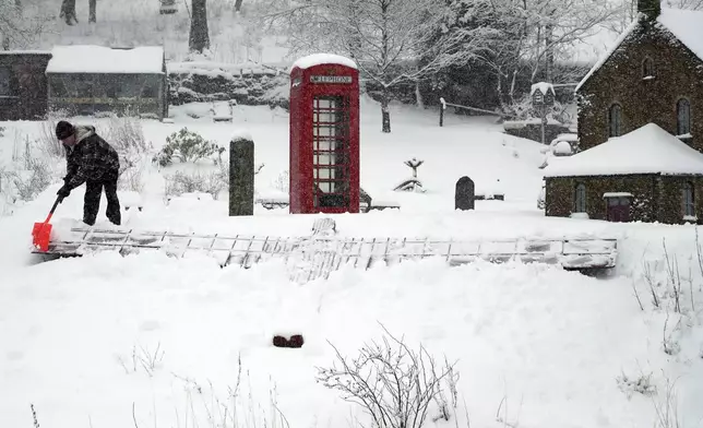 Lowson Robinson is pictured in the heavy snow with his scaled miniature famous landmarks which are located in his garden in Nenthead, England, as the severe weather continues across England, Sunday, Jan. 5, 2025. (AP Photo/Scott Heppell)