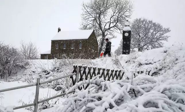 Lowson Robinson is pictured in the heavy snow with his scaled miniature famous landmarks which are located in his garden in Nenthead, England, as the severe weather continues across England, Sunday, Jan. 5, 2025. (AP Photo/Scott Heppell)