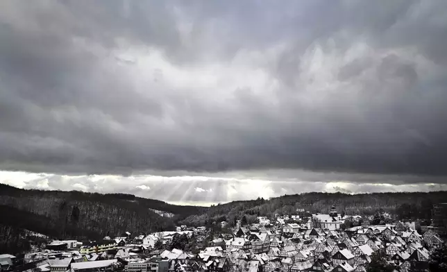 Snow falls on the roofs of the half-timbered houses in the historic city center in Freudenberg, Germany, Friday, Jan. 3, 2025. (Federico Gambarini/dpa via AP)